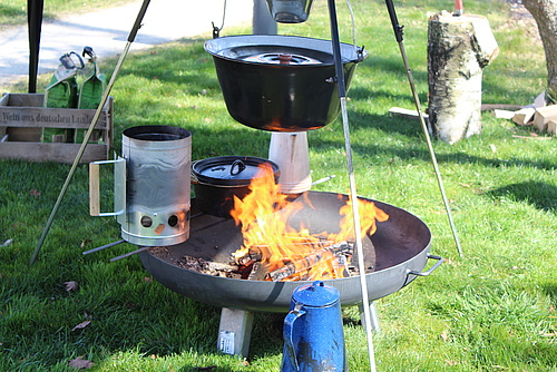 Brennende Feuerschale mit Dreibein und Kochkessel