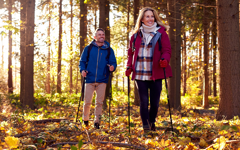 Mann und Frau spazieren durch einen Herbstwald