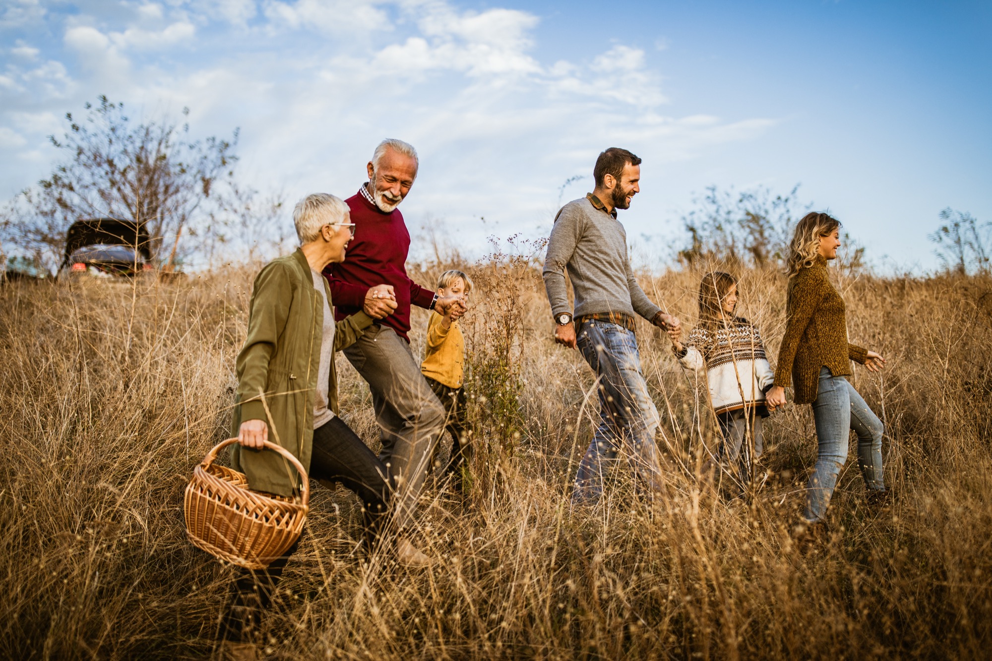 Familie wandert im Herbst durch ein Weizenfeld