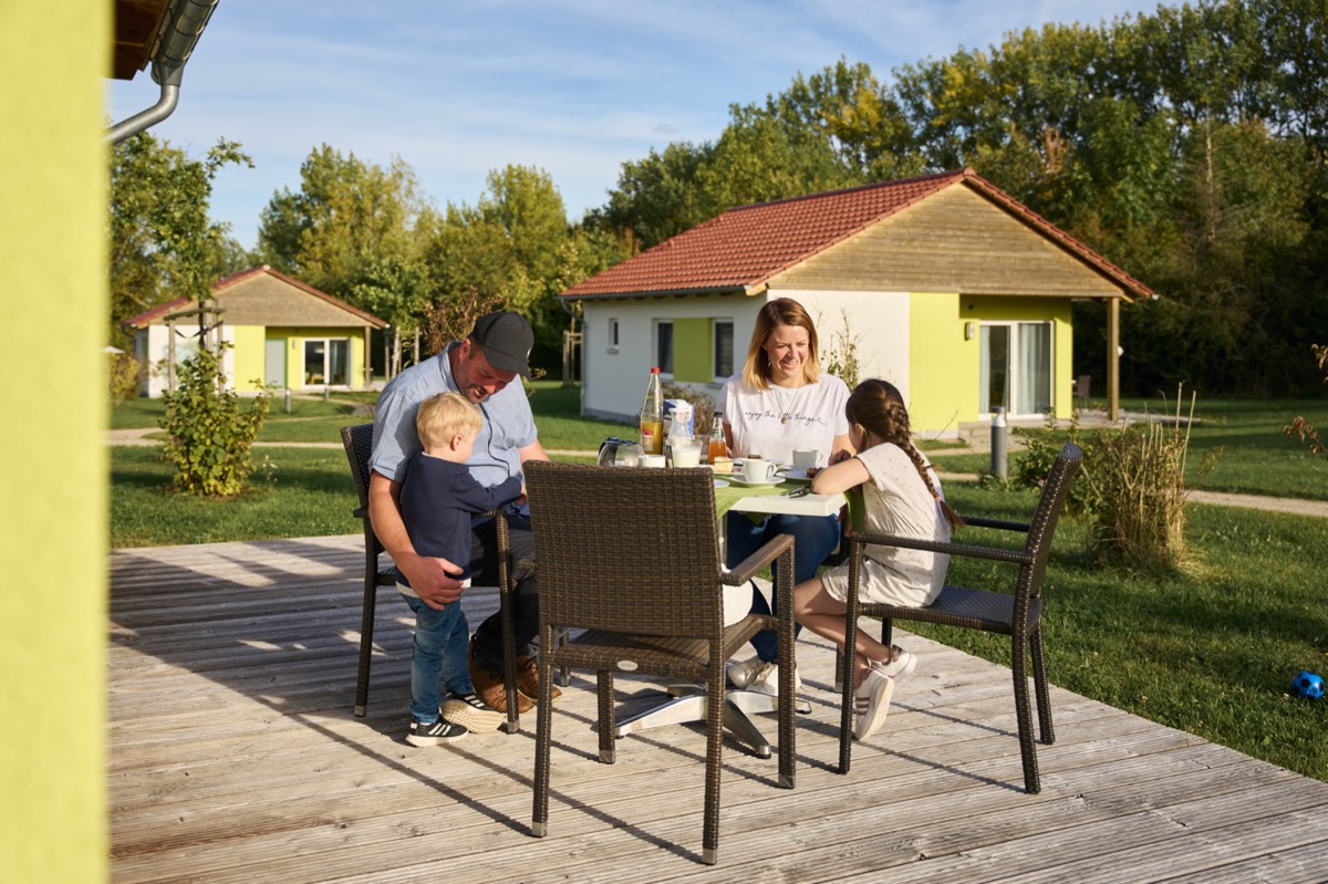 Familien isst am Ferienhaus auf der Terrasse
